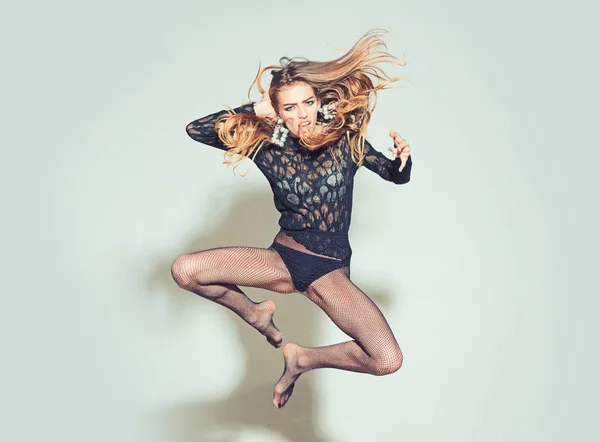 Salto y estilo de vida activo. chica saltando con el pelo largo y pendientes de lujo . — Foto de Stock