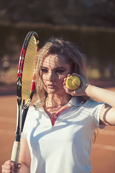 Frauen halten Schläger und Ball auf dem Rasen. sinnliche Frau auf dem Tennisplatz. Tennisspieler beim Training auf sonnigem Platz. Sportlerin in modischer Sportbekleidung auf dem Platz. Sportliches Aktivitäts- und Wellness-Konzept — Stockfoto