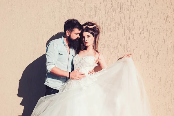 Moda e romance. Noiva sensual em vestido de noiva branco. Esposo barbudo em roupas casuais. Homem e mulher de moda. Casal romântico apaixonado. Casal de amantes com estilo de moda — Fotografia de Stock