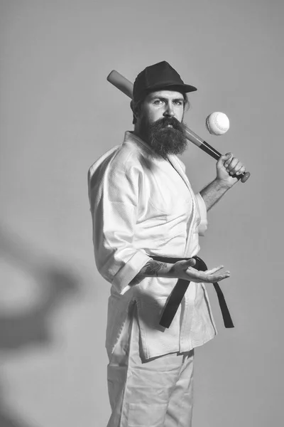 bearded karate man in kimono, cap, green baseball bat, ball