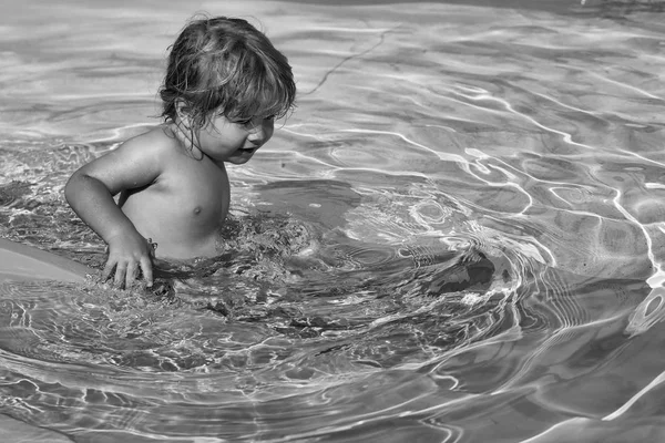 Niño lindo deslizándose desde el tobogán de agua amarillo — Foto de Stock