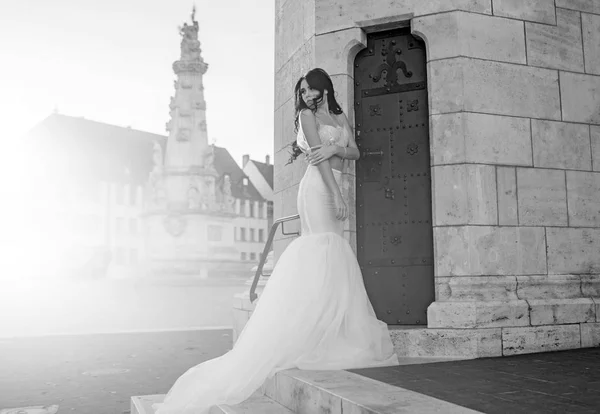 Woman at stone ancient tower in summer. Wedding fashion and beauty salon. Bride girl at wedding ceremony in castle. Fashion model or princess in dress. Sexy girl in white dress with stylish hair