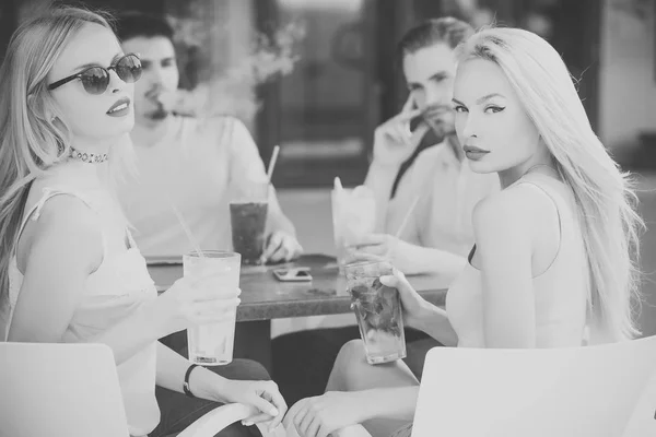 Vrouwen twins en mannen vrienden ontspannen in café buiten — Stockfoto
