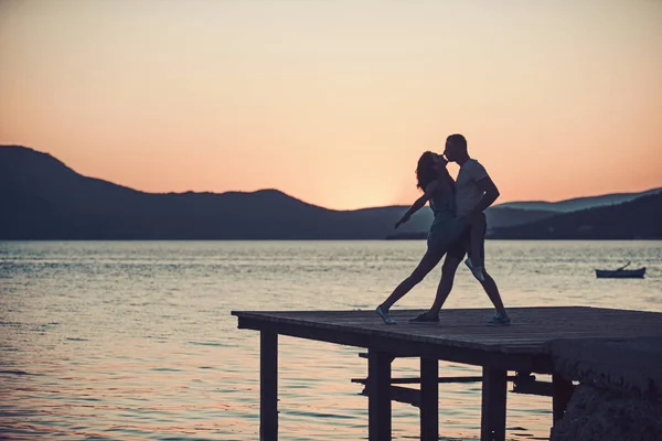 Jeune fille et homme à l'eau de mer au coucher du soleil. Vacances d'été et vacances de voyage. Famille et Saint Valentin. Couple amoureux se détendre sur la plage du lever du soleil. Relations amoureuses de couple profitant de la journée d'été ensemble — Photo