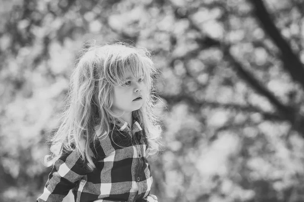 Criança com longos cabelos loiros em camisa xadrez ao ar livre — Fotografia de Stock