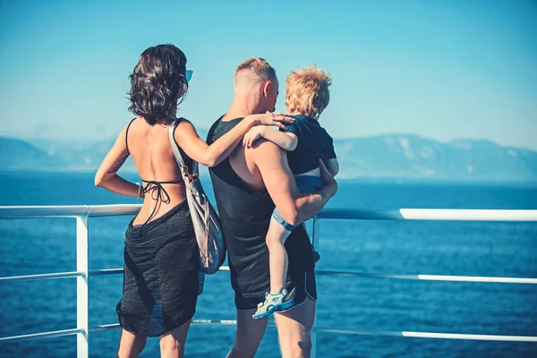 Férias de verão de família feliz. Mãe e pai com filho olham para o mar na praia. Viagem familiar com criança no dia de mães ou pais. Criança com pai e mãe. Amor e confiança como valores familiares . — Fotografia de Stock