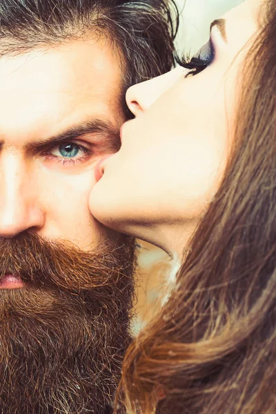Bearded man with long beard kissed by woman. Bearded hipster and sensual woman