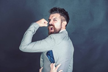 Kızgın adam sahte veya sahte marka satın aldı. Sakallı adam koyu arka plan üzerinde delik ile ceket giyer. Hipster küçük boyutlu ceket, eller ile parçalanmış dikiş açmadı. Kötü kalite giyim kavramının