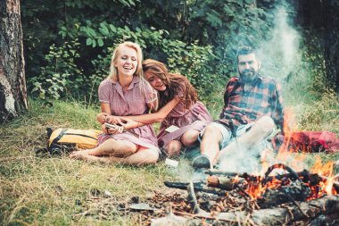 Sakallı adam ve kadın şenlik ateşinde gülümse. Mutlu arkadaş, kamp ateşi. Hipster palid gömlekli ve vintage elbiseler kız ormanda sakin ol. Yaz tatil kavramı. Kamp seyahat ve yolculuk tutkusu, retro