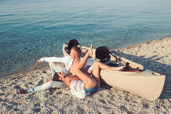 夏の休日や休暇を旅行します。一緒に夏の日を楽しんでいるカップルの関係が大好きです。セクシーな女とボート付近における海水の男。家族とバレンタインの日。愛のカップルは砂浜でリラックスします。 — ストック写真