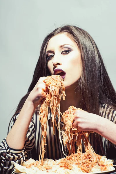 Seksi kadın elleriyle spagetti yemek. İtalyan yemeği yemek aç kız var. Güzellik makyaj ve uzun esmer saç modeliyle akşam yemeği var. Kadın Domates ketçap ile makarna yemek ye. Gıda, diyet ve mutfağı — Stok fotoğraf