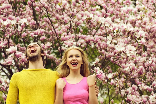 Glückliches Liebespaar im Garten am blühenden Magnolienbaum — Stockfoto