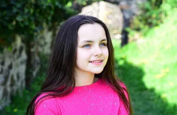 O olhar polido. Menina bonita com penteado natural em linha reta no dia da primavera. Menina bonito com penteado longo na paisagem primavera. Menina criança com cabelo morena saudável. Melhor aparência de cabelo longo — Fotografia de Stock