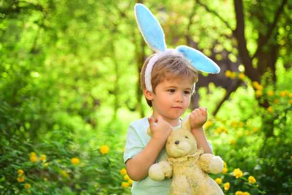 Láska Velikonoce. Rodinná dovolená. Malý chlapec v zeleném lese. Vajíčka na jarní dovolenou. Veselé velikonoce. Dětství. Králík kluk s uši. Hračka zajíc. Hravou náladu — Stock fotografie