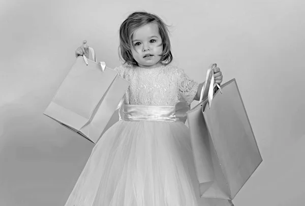 Infância feliz de menina. Miúdo às compras. sacos de compras. Um presente de Natal. Obrigado pela sua compra. grande venda no shopping center. Feliz aniversário. Festa de Ano Novo. criança menina pequena com pacote presente — Fotografia de Stock