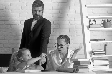 Geri okul ve evde eğitim için. geri okul kavramı gösterir akıllı kızlar okulda sakallı öğretmen ile çalışma..