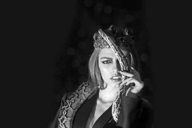 Makyaj yüz ve yılan olan kadın. Güzellik kraliçesi tutun python. Şehvetli kadın yılanla. Takı taç başındaki uzun saçlı güzellik modelinde. Arzu günaha veya tehlike kavram