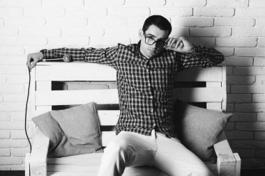 adam gözlük ve mikrofon ile bankta kareli gömlek