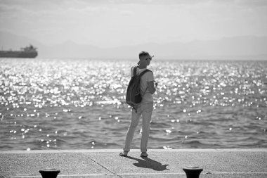 adam gezgin uzakta denizde seyir su sırt çantası ile. seyahat ve yolculuk tutkusu kavramı. yaz tatili ve maceraları. Genç adam deniz gezisi gidiyor. futute hayat kavramı