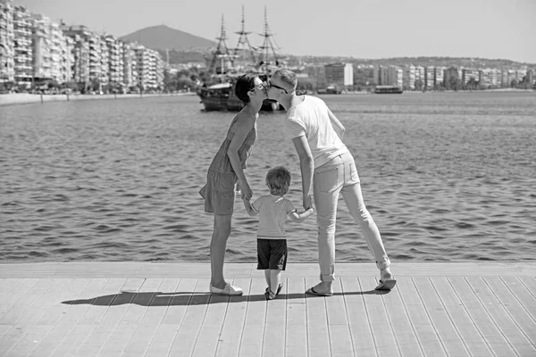 Niño con padre y madre. niño con padres besándose en la bahía . — Foto de Stock