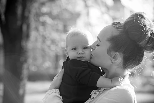 Matka kiss málo syna s láskou. Žena s dítětem. Máma a dítě chlapec venkovní. Matek den koncept. Šťastná rodina si slunečný den. Péče o lásce a důvěře — Stock fotografie