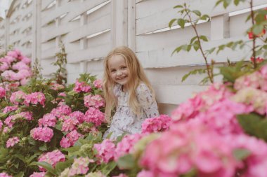 Bahar çiçekleri. Çocukluk. Küçük kıza çiçek açan çiçek. Yaz. Gün anneler veya kadın. Çocuk günü. Küçük bebeğim. Yeni yaşam konsepti. Bahar tatili. mutlu kız. Bahar stili