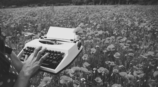 Máquina de escribir vintage naranja con una mano de escritor . —  Fotos de Stock