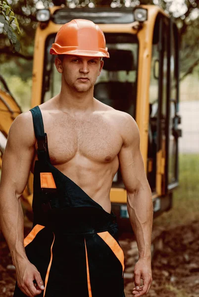 Concept d'opérateur. Exploitant de la pelle sur chantier. Opérateur musculaire en uniforme de travail. Opérateur de machine avec pelleteuse — Photo