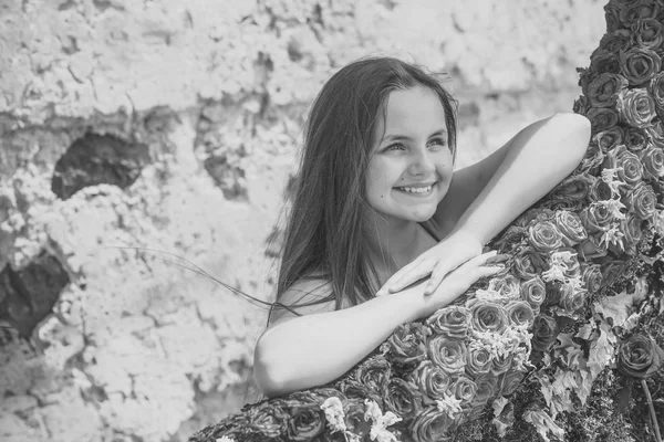 Petite fille avec des fleurs roses rouges — Photo