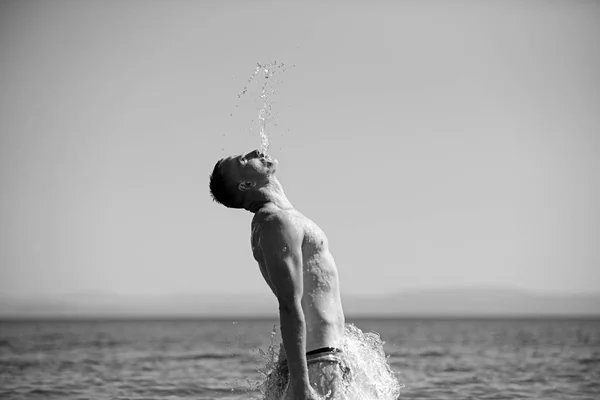 Homme sauter de l'eau. vacances d'été et Voyage. nager et s'amuser en mer. sport et mode de vie sain. concept de liberté et d'énergie. sportif gars sauter dans l'eau de mer à miami plage au coucher du soleil — Photo