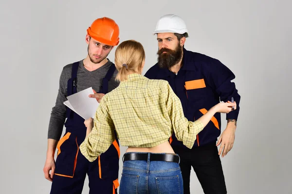 Creating perfection. Construction workers team. Professional people working on construction design. Group of constructing engineers and architects at work. Men and woman builders working in team