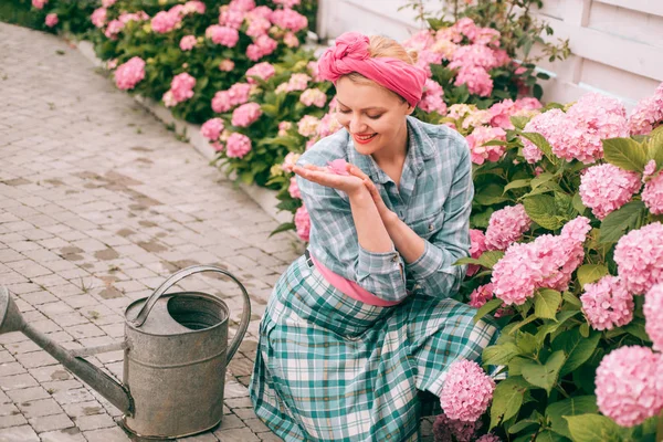 アジサイ。春と夏。幸せな女庭師の花。花の世話と水やり。土壌と肥料。庭の花の世話を女性。温室の花。植物と彼女の仕事を楽しんでいます。 — ストック写真