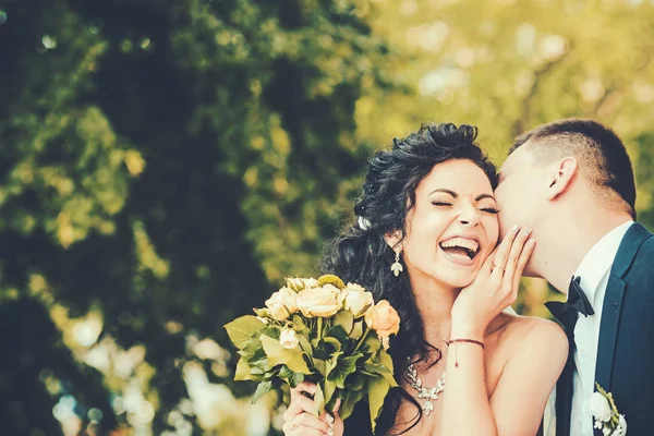 Casal no amor beijar e sorrir no dia do casamento. Casal apaixonado no verão ao ar livre — Fotografia de Stock