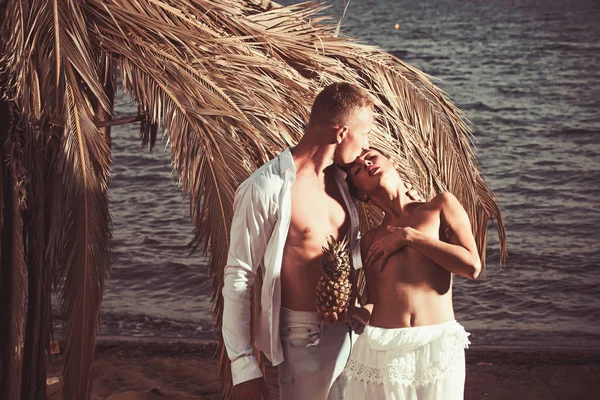 Junges nacktes Paar steht an einem tropischen Sandstrand. — Stockfoto