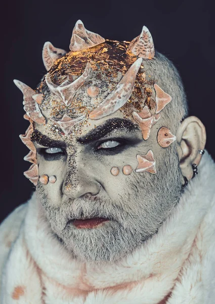 Uzaylı, iblis büyücü makyaj. Siyah arka plan, cehennemdeki şeytanlar kapatın. Karanlık sanatlara kavramı. Beyaz sakallı komuta sizde canavar gibi giyinmiş. Dikenler veya siğiller kürk paltolu adam.