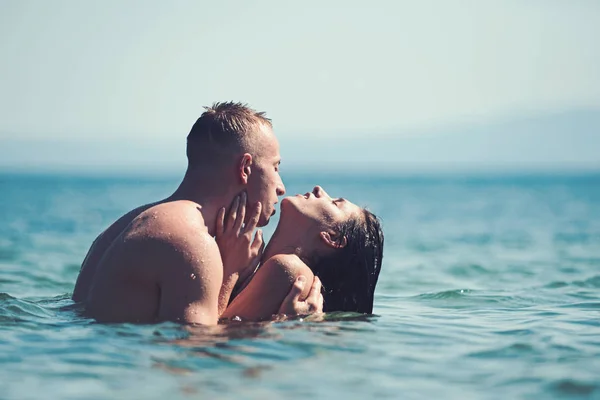 Verliebte Paare entspannen sich am Strand. Verliebtes Paar küsst sich im Sommer im Meerwasser. — Stockfoto