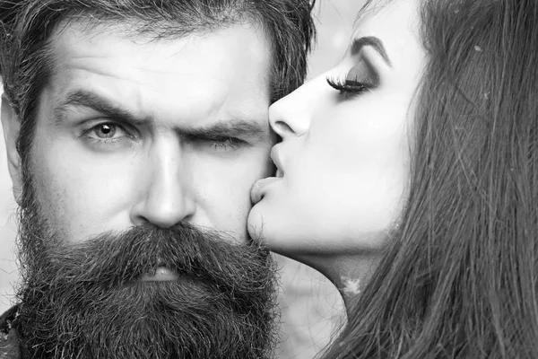 Mulher beija hipster com barba comprida, amor. Mulher sensual com pele de maquiagem e homem barbudo. Casal no amor e conceito de família. Salão de beleza e barbearia. Skincare e conceito de cuidado do cabelo — Fotografia de Stock