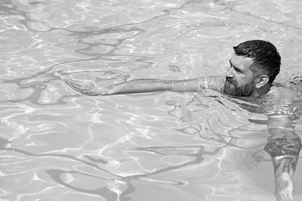 暑假和去海边旅行。有胡子的人在蓝色的水里游泳。在 spa 游泳池、茶点和护肤品中放松身心。马尔代夫或迈阿密海滩。在巴哈马加勒比海的男子时髦 — 图库照片