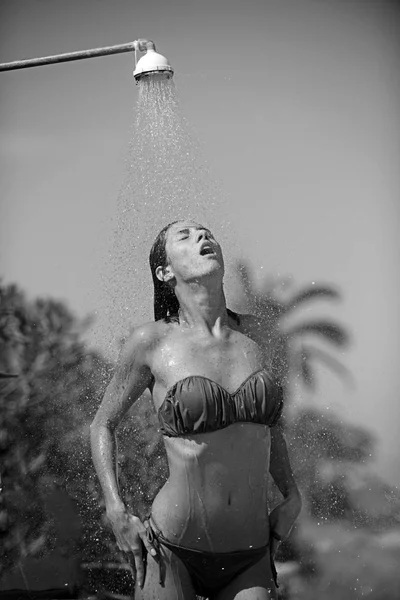 Mulher tomando banho fora no jardim balinês verde tropical com muitas palmas. Salpicos frescos de água limpa. Spa de luxo . — Fotografia de Stock
