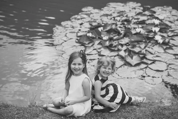 Діти щасливі посмішки на зеленому озерному пейзажі — стокове фото
