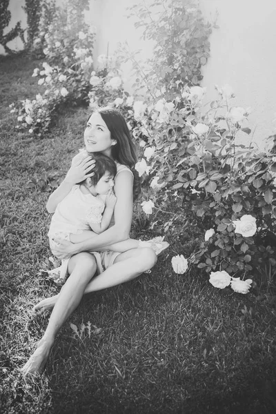 Mulher sentada com bebê na grama verde — Fotografia de Stock