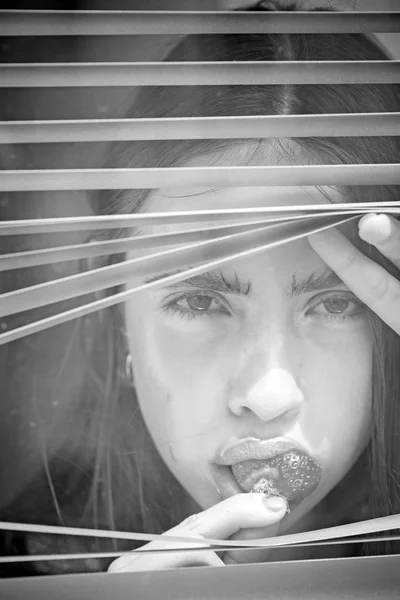 Ung kvinna med bär i munnen — Stockfoto