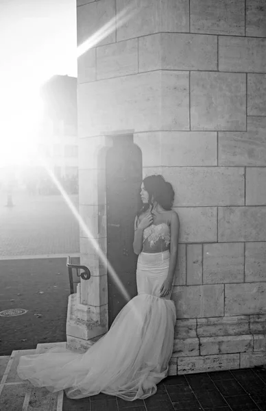 Bride girl at wedding ceremony in castle. Wedding fashion and beauty salon. Fashion model or princess in dress. Sexy girl in white dress with stylish hair. Woman at stone ancient tower in summer