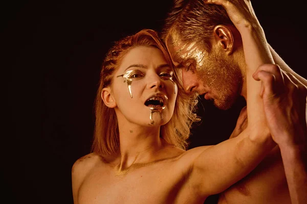 Erotické hry pár v lásce. erotické hry páru se zlatem na těle izolované na černém. — Stock fotografie