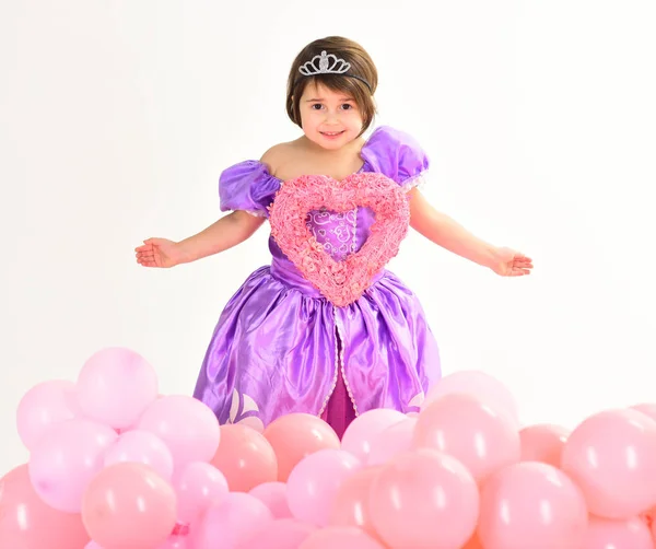 Dia dos Namorados. Felicidade infantil. Moda infantil. Pequena falta em vestido bonito. Dia das crianças. Pequena criança bonita segurar o coração. Menina em vestido de princesa. Balões de festa. Feliz aniversário. — Fotografia de Stock