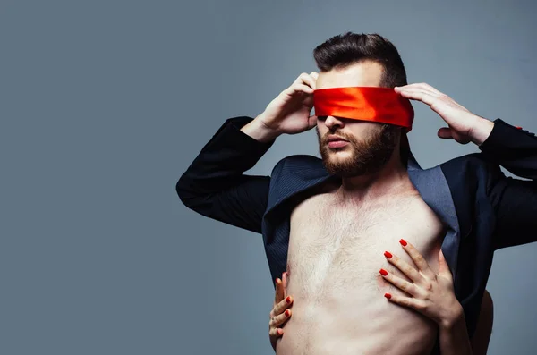 Blindfolded. Sexy girl closes eyes of a man. Woman covering man eyes.