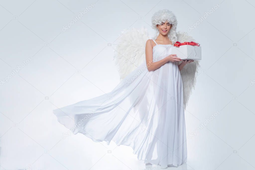 Girl with angel wings and a white dress. Angel girl. Cupid woman.