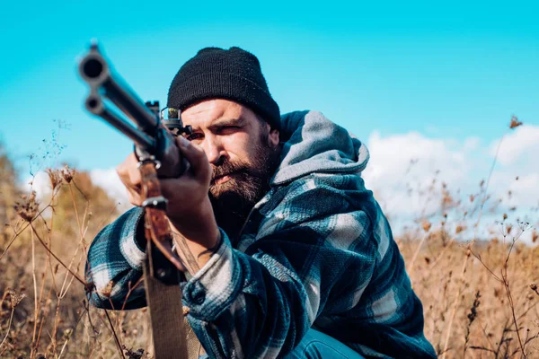 Jakt i Amerika. Jägare med hagelgevär pistol på jakt. Hunter syftar gevär i skogen. Hunter mannen. Perioden, jaktsäsongen. Hane med en pistol. — Stockfoto