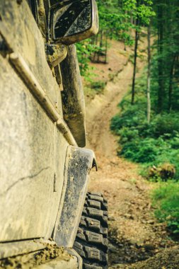 Alt görünümü büyük offroad araba tekerlek ülke road ve dağlar zemin üzerinde. Offroad araç bir çamur delik tehlikesi dışarı geliyor. Off-road aracı dağda gider.