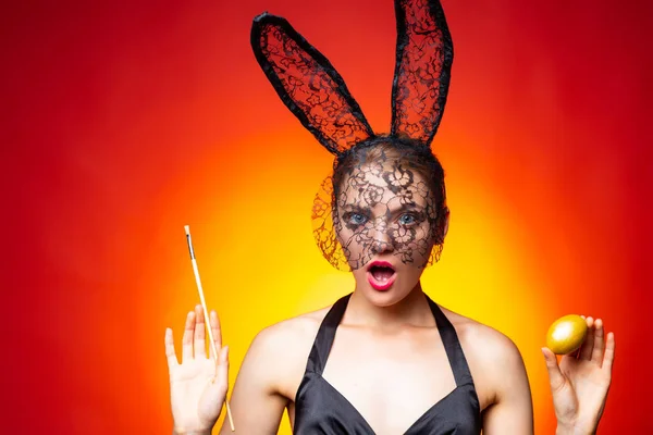 Kobieta trzyma malowane jajka. Bunny uszy królika kostium. Młoda kobieta ubrana w Wielkanoc bunny uszy. — Zdjęcie stockowe